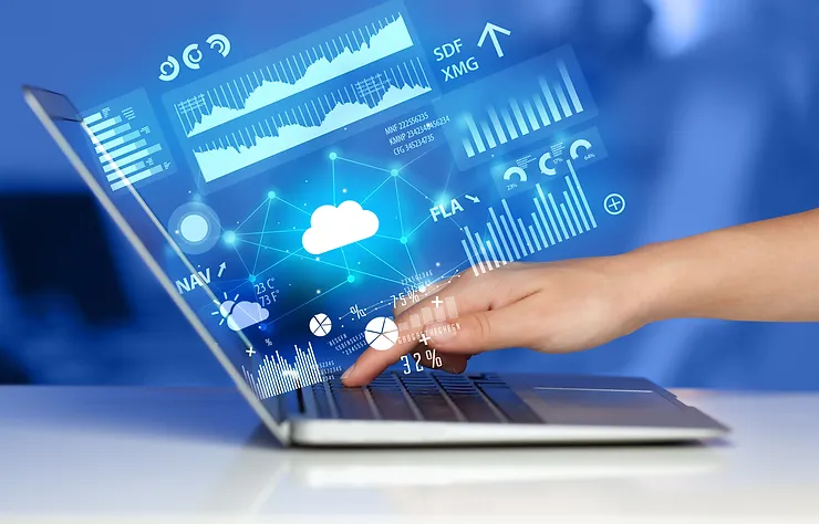 A hand interacts with a laptop displaying digital graphs, charts, and cloud computing icons on a blue background.