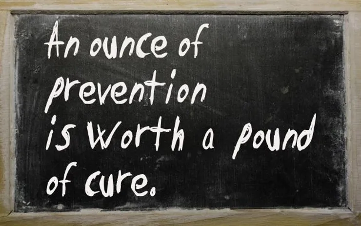 A chalkboard displays the phrase "An ounce of prevention is worth a pound of cure" in white handwriting.