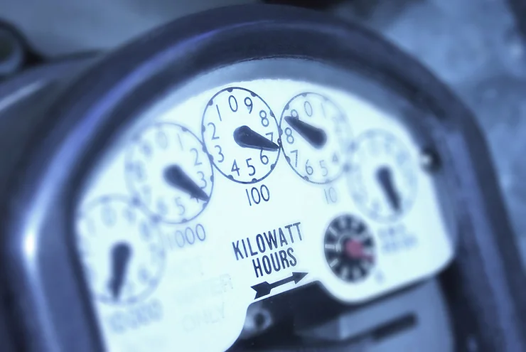 Close-up of a vintage analog kilowatt-hour meter with dials showing electrical consumption.